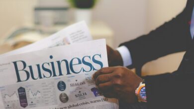 person wearing suit reading business newspaper